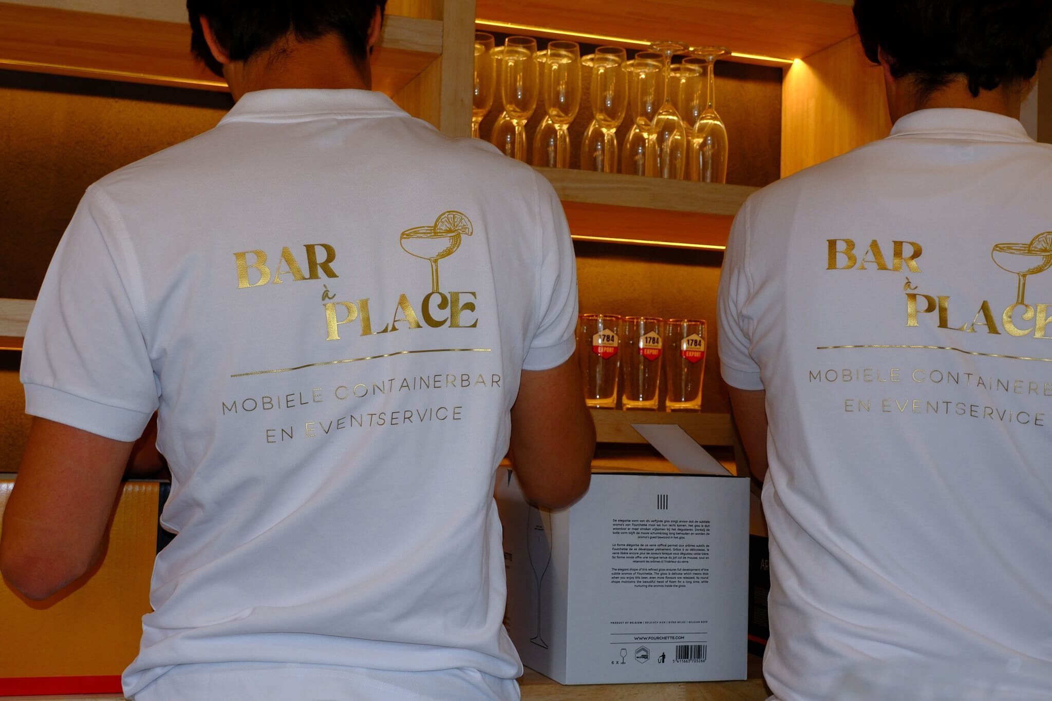 Teamleden met champagneglazen aan de bar
